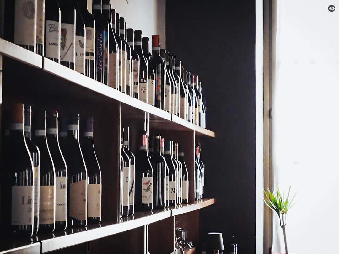 Le bottiglie di vino sugli scaffali dell'enoteca dell'Osteria della Chiocciola a Cuneo